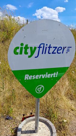 Ein Pin-Schild am cityflitzer-Hub mit der Aufschrift "cityflitzer, reserviert"
